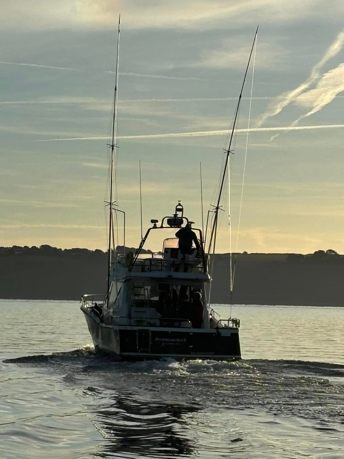 Dreamcatcher heading out of Falmouth at dawn with outriggers raised